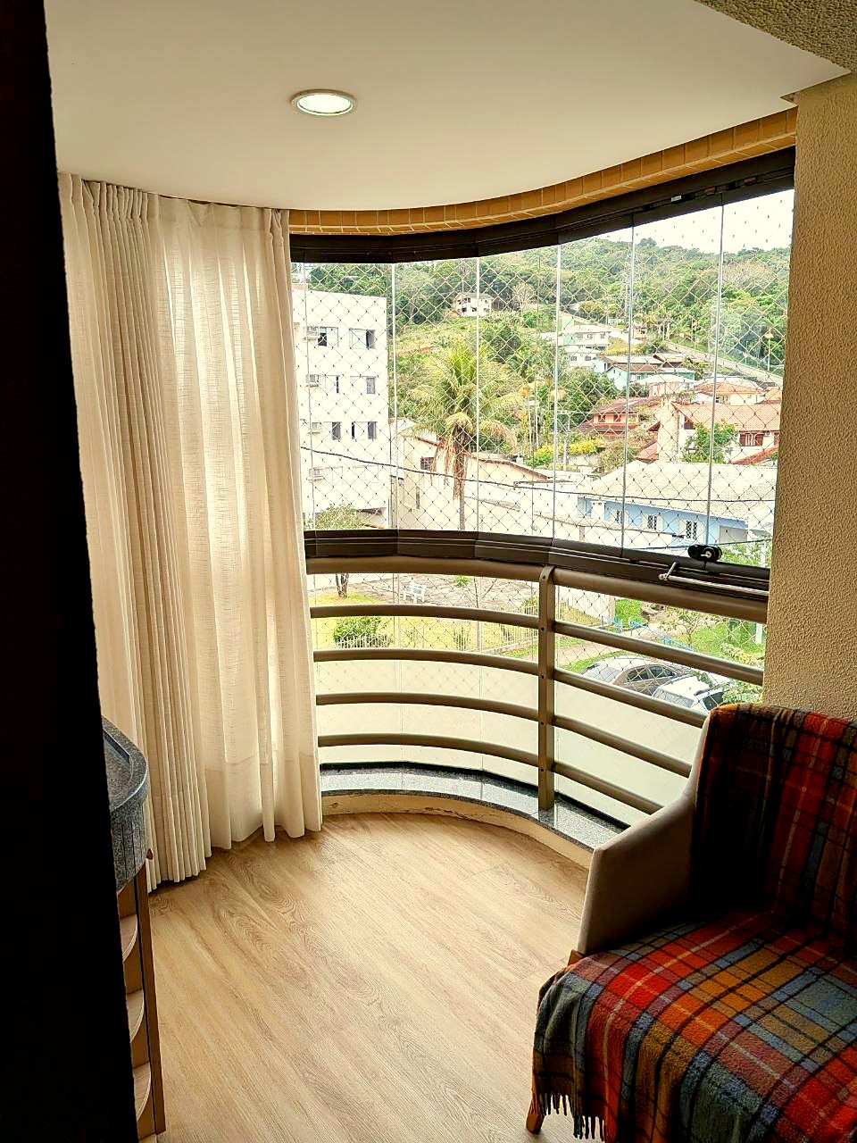 Varanda envidraçada com vista para o bairro