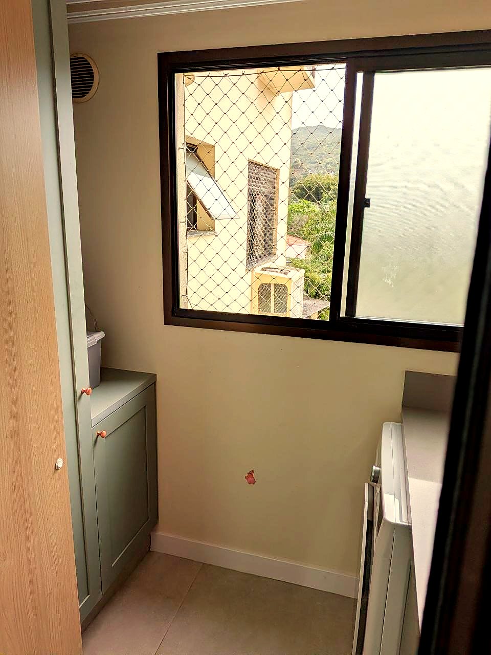 Área de serviço com armários sob medida e janela com vista